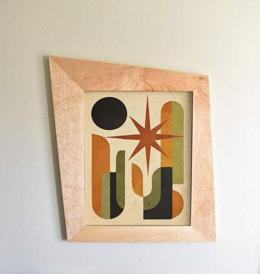 Mid-century modern maple trapezoid picture frame styled with art.